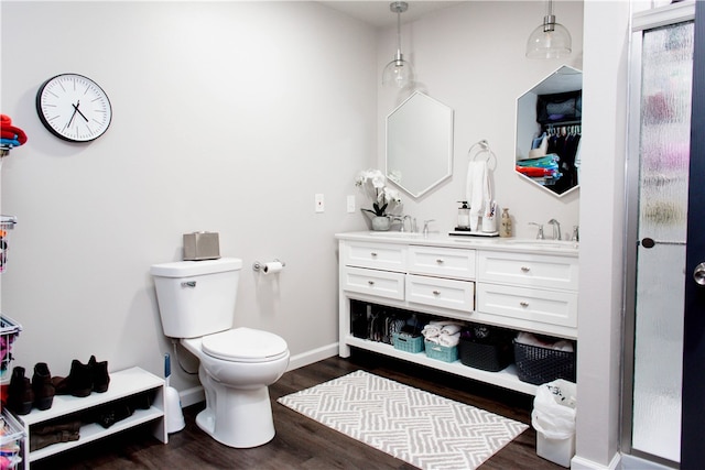 bathroom featuring toilet, a shower with door, hardwood / wood-style floors, and vanity