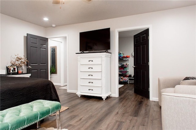 bedroom featuring recessed lighting, wood finished floors, baseboards, a spacious closet, and a closet