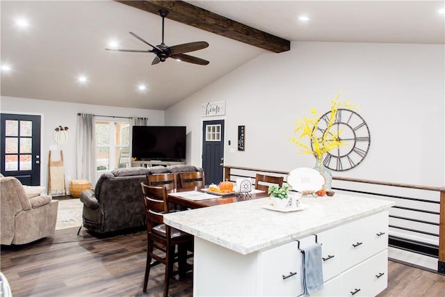 kitchen with white cabinets, lofted ceiling with beams, open floor plan, dark wood-type flooring, and a center island