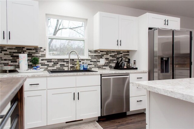 kitchen featuring white cabinetry, sink, dark hardwood / wood-style floors, appliances with stainless steel finishes, and backsplash