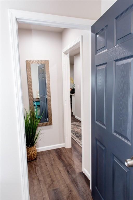 hall with dark wood-style floors and baseboards