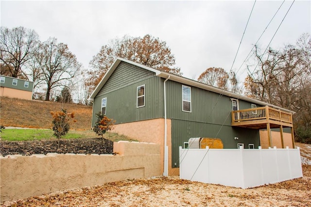 view of property exterior featuring fence and a wooden deck