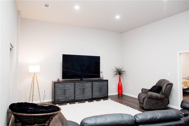 living area with recessed lighting, wood finished floors, visible vents, and baseboards