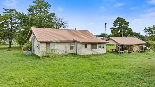 rear view of property featuring a lawn