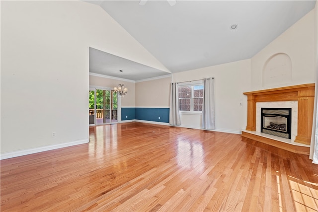 unfurnished living room featuring high vaulted ceiling, an inviting chandelier, light hardwood / wood-style flooring, crown molding, and a high end fireplace