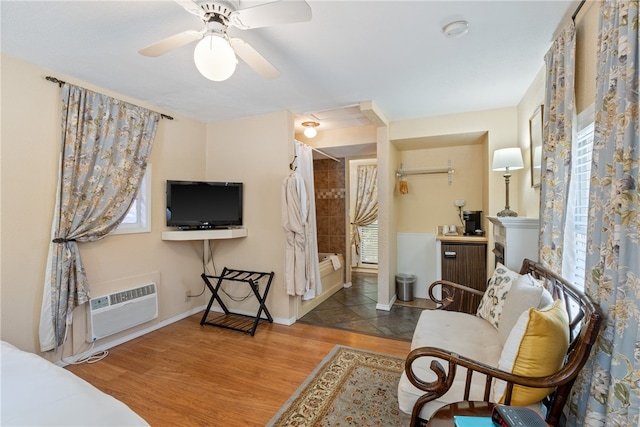 living room with tile patterned floors, an AC wall unit, and ceiling fan