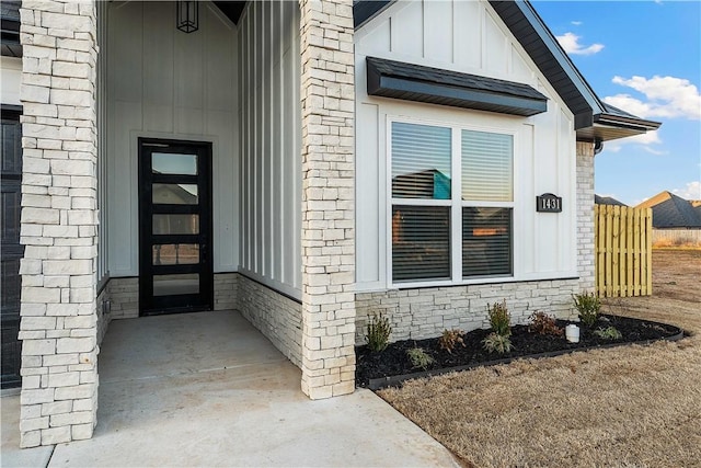 view of exterior entry with brick siding and board and batten siding