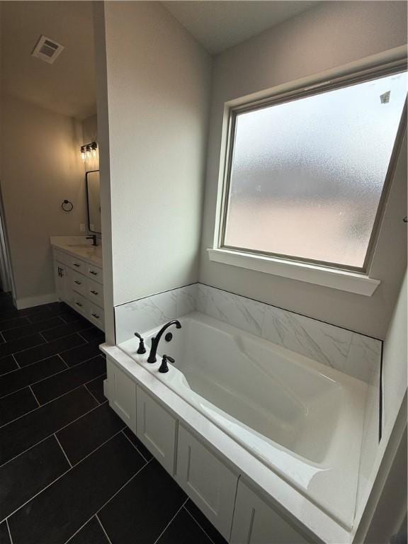 bathroom featuring vanity, a bathing tub, and tile patterned floors