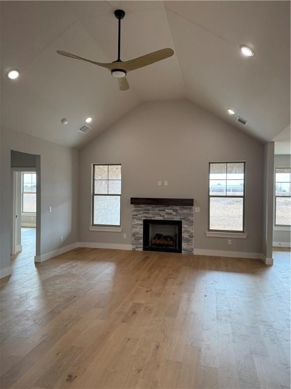 unfurnished living room with a tile fireplace, vaulted ceiling, ceiling fan, and light hardwood / wood-style floors