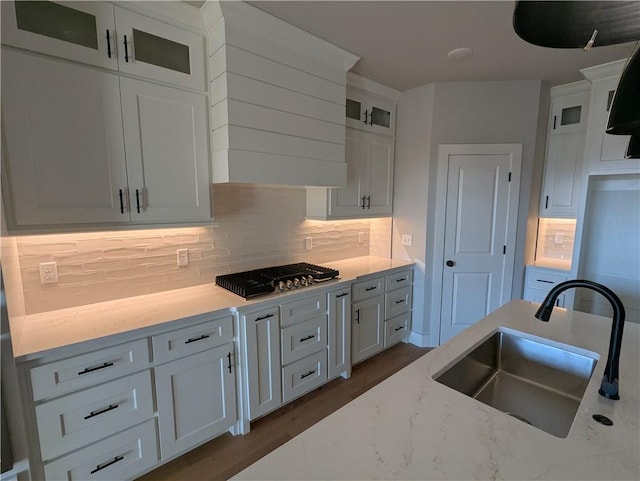 kitchen featuring sink, white cabinets, and light stone counters