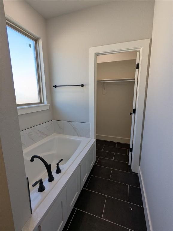 bathroom with a washtub and tile patterned floors