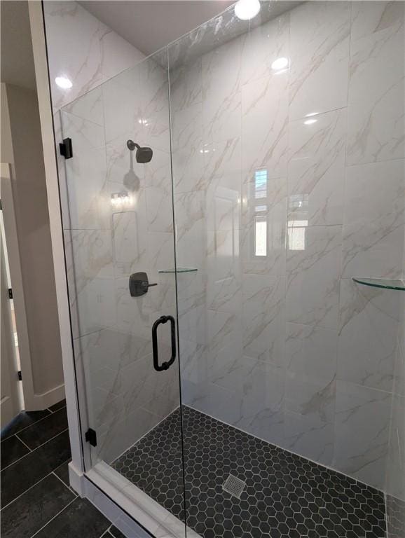 bathroom featuring a shower with shower door