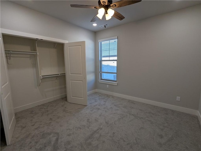 unfurnished bedroom featuring light carpet, vaulted ceiling, a closet, and ceiling fan