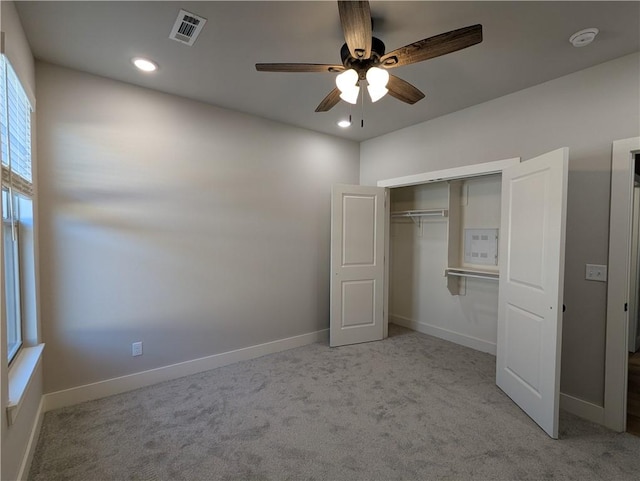 unfurnished bedroom with light carpet, a closet, and ceiling fan