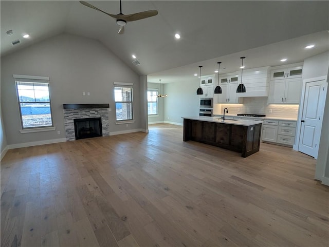 kitchen featuring sink, white cabinets, ceiling fan, light hardwood / wood-style floors, and a center island with sink