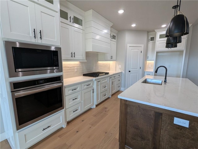 kitchen featuring pendant lighting, sink, white cabinets, and appliances with stainless steel finishes