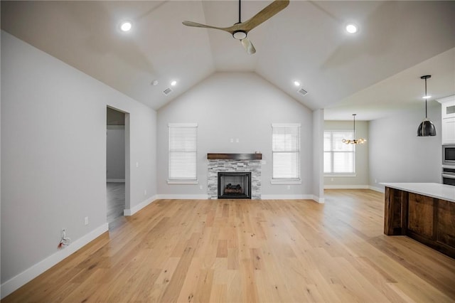 7843 Range Ave, Springdale, AR 72762 - unfurnished living room with a ceiling fan, a chandelier, light wood-type flooring, a fireplace, and vaulted ceiling