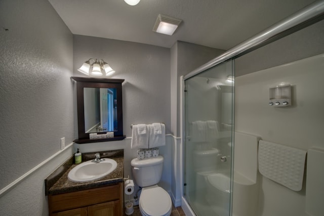 bathroom with walk in shower, toilet, and vanity