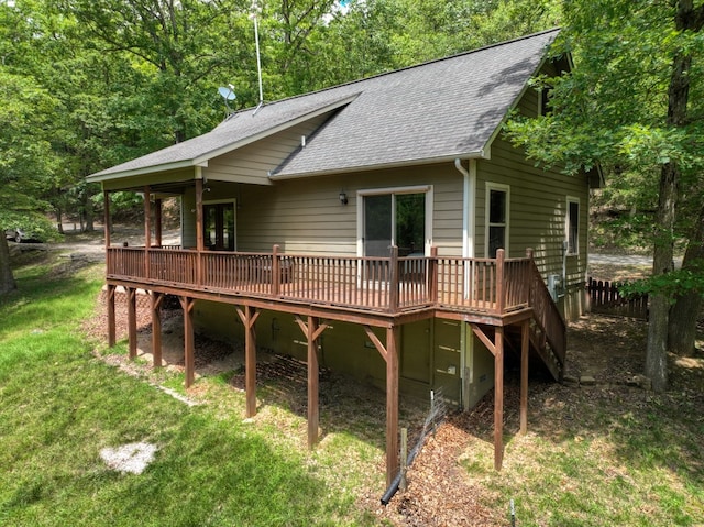 back of property featuring a deck and a lawn