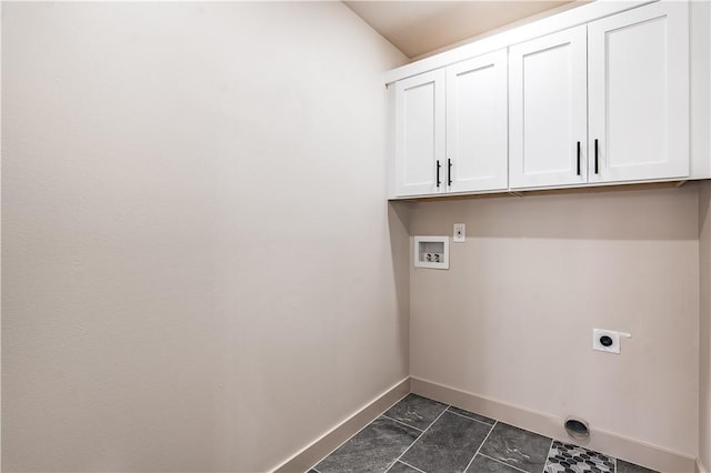 laundry area with hookup for a washing machine, cabinet space, electric dryer hookup, dark tile patterned flooring, and baseboards