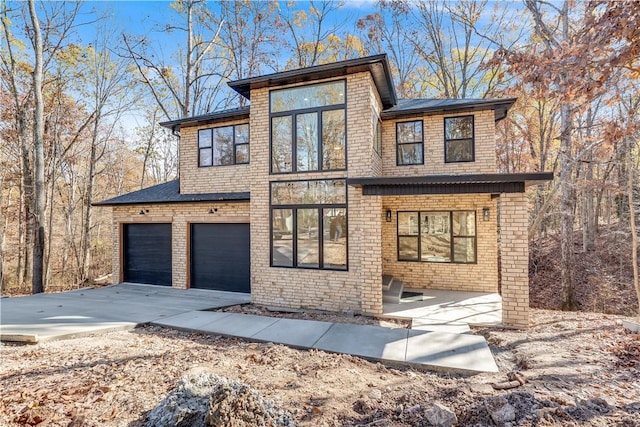 view of front of property with driveway and brick siding