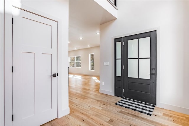 foyer entrance with recessed lighting, light wood-style flooring, and baseboards