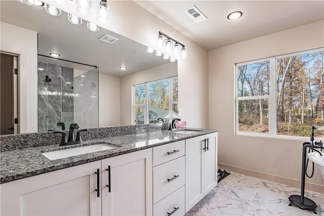 full bath with marble finish floor, visible vents, a sink, and a shower stall