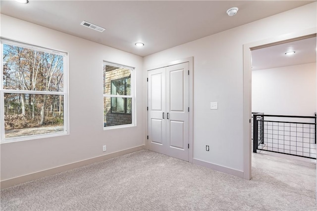 unfurnished bedroom with baseboards, visible vents, and carpet flooring