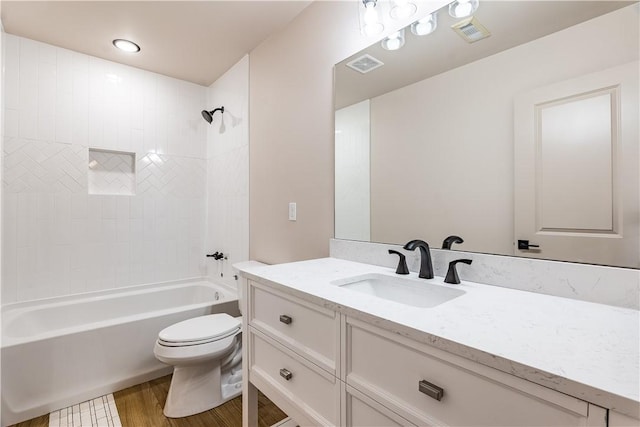 full bathroom with visible vents, toilet, vanity, wood finished floors, and shower / bathtub combination