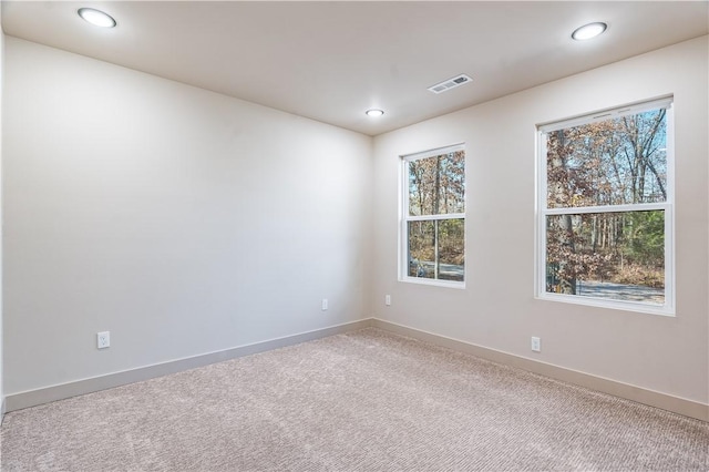 unfurnished room with baseboards, visible vents, carpet flooring, and recessed lighting