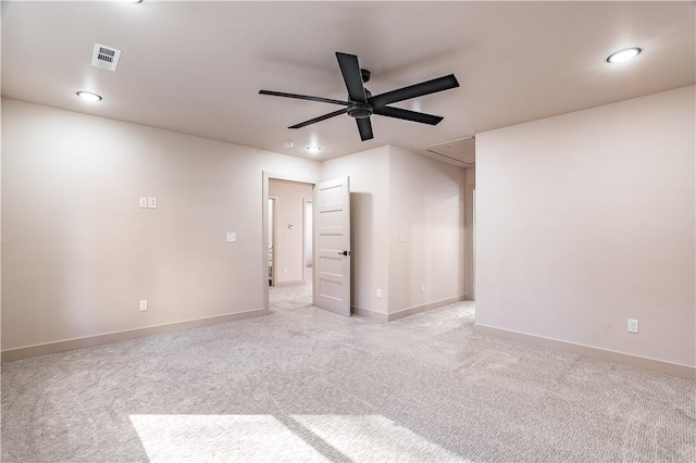 spare room featuring ceiling fan, light carpet, visible vents, baseboards, and attic access