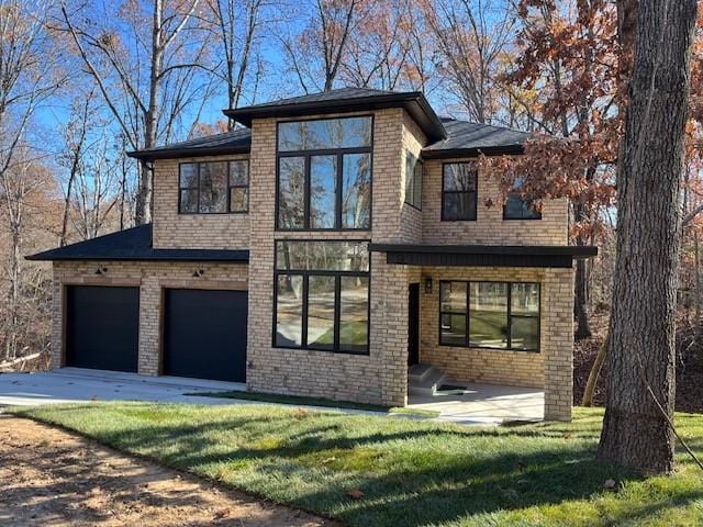 view of front of property featuring a garage, concrete driveway, brick siding, and a front yard