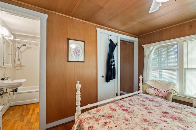 bedroom featuring ceiling fan, wooden walls, and wooden ceiling