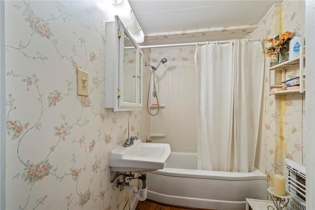 bathroom featuring shower / tub combo with curtain and sink