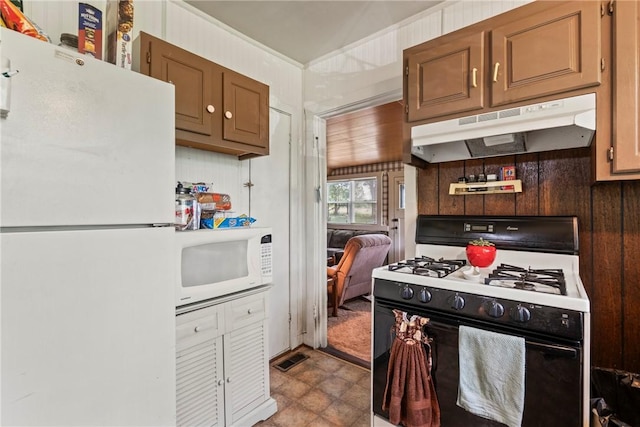 kitchen featuring wood walls and white appliances