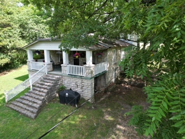 view of outbuilding featuring a porch and a yard