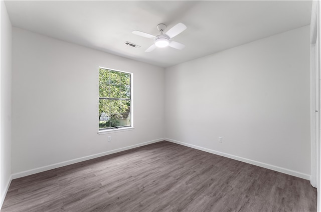 empty room with ceiling fan and dark wood-type flooring