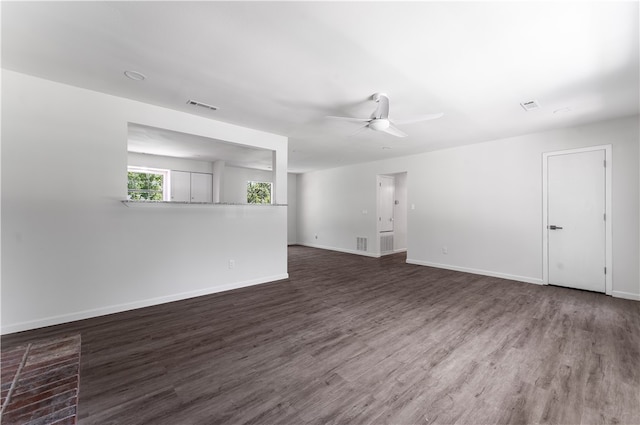 unfurnished living room featuring ceiling fan and dark wood-type flooring