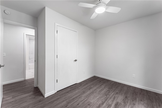 unfurnished bedroom with a closet, ceiling fan, and dark hardwood / wood-style flooring