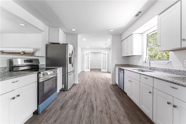 kitchen with light stone counters, white cabinets, sink, hardwood / wood-style flooring, and appliances with stainless steel finishes