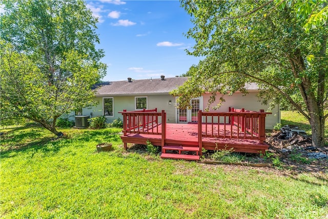 back of house featuring central AC unit, a wooden deck, and a yard