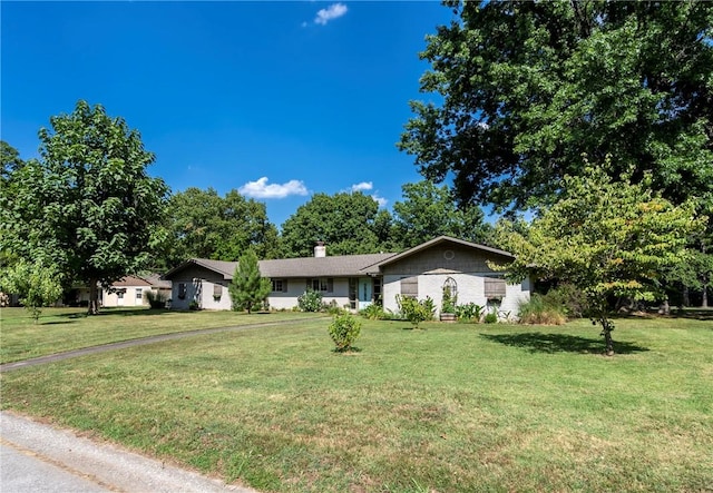 single story home with a chimney and a front lawn