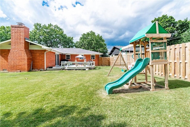 view of play area with a yard and a wooden deck