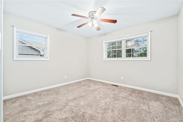 carpeted empty room with ceiling fan and a healthy amount of sunlight