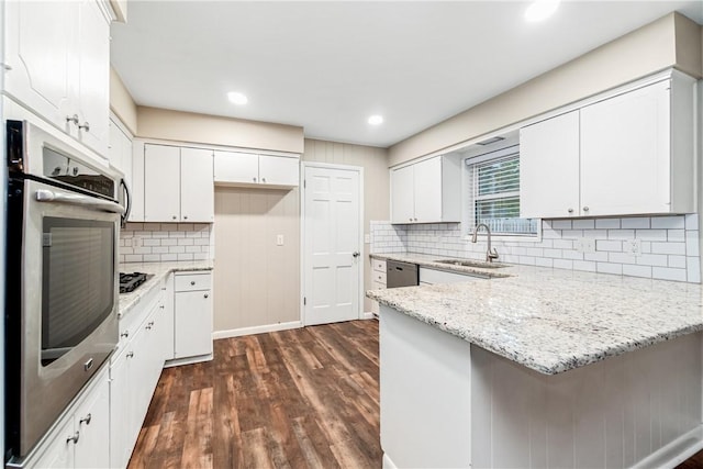 kitchen featuring light stone countertops, appliances with stainless steel finishes, white cabinetry, and sink