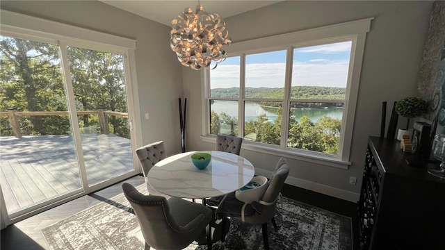 dining room featuring a water view, a wealth of natural light, and an inviting chandelier