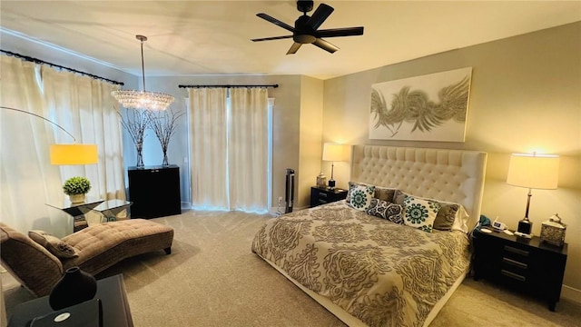 carpeted bedroom featuring ceiling fan with notable chandelier