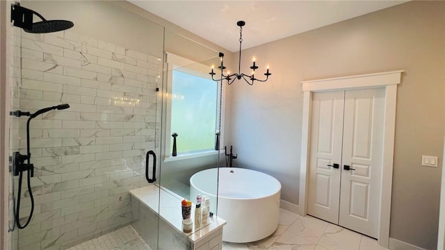 bathroom featuring marble finish floor, a freestanding tub, a shower stall, and baseboards