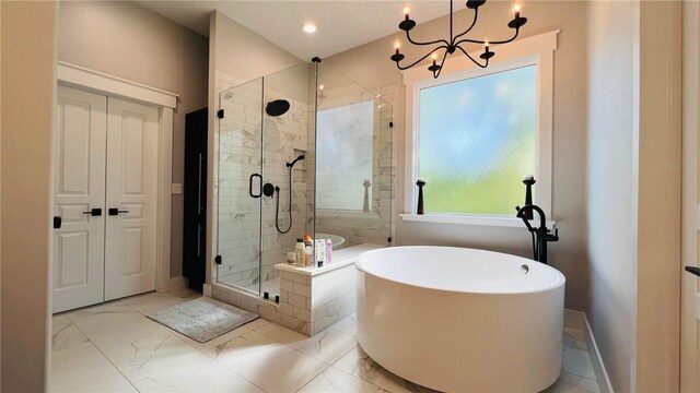 bathroom with shower with separate bathtub, tile patterned floors, and a chandelier