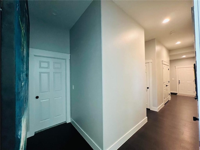 corridor featuring dark wood-style floors, recessed lighting, and baseboards